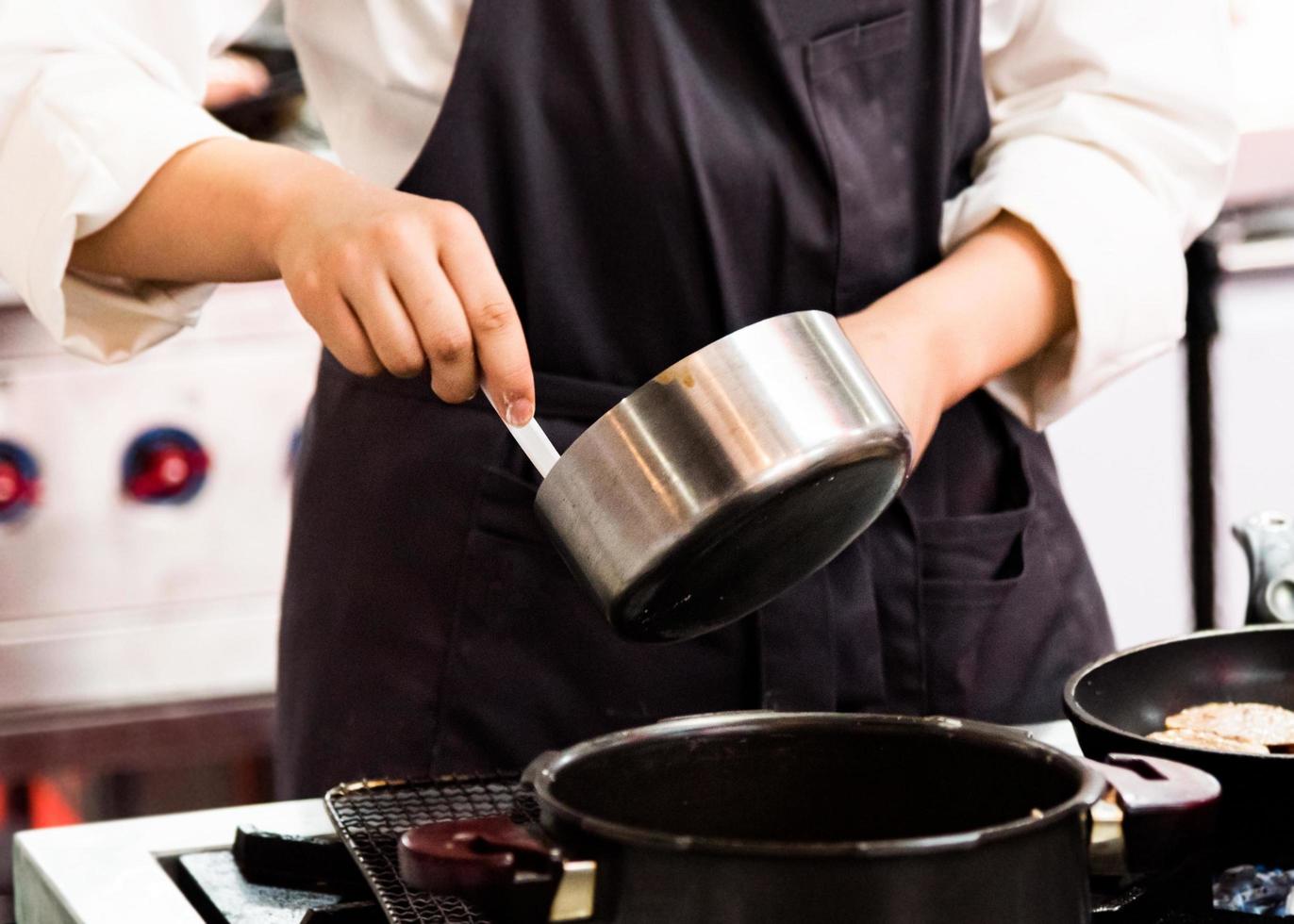 chef-kok koken, chef-kok bereiden van voedsel in de keuken, close-up foto