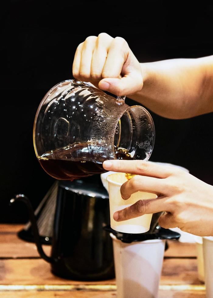 barista die koffie maakt, barista die druppelkoffie in glas giet foto