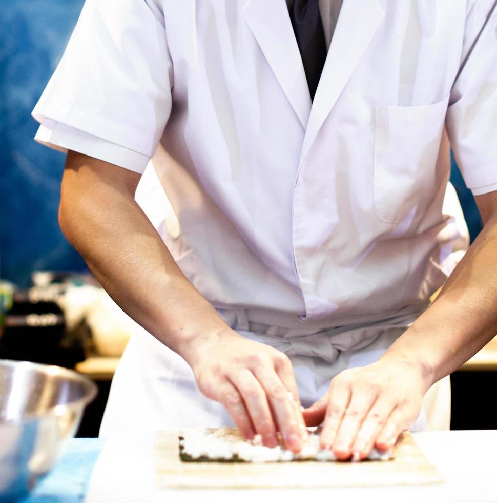 chef-kok handen die Japans eten bereiden, chef-kok die sushi maakt foto