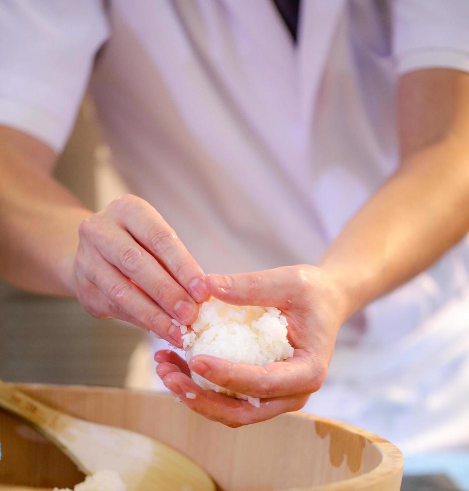 chef-kok handen die Japans eten bereiden, chef-kok die sushi maakt foto