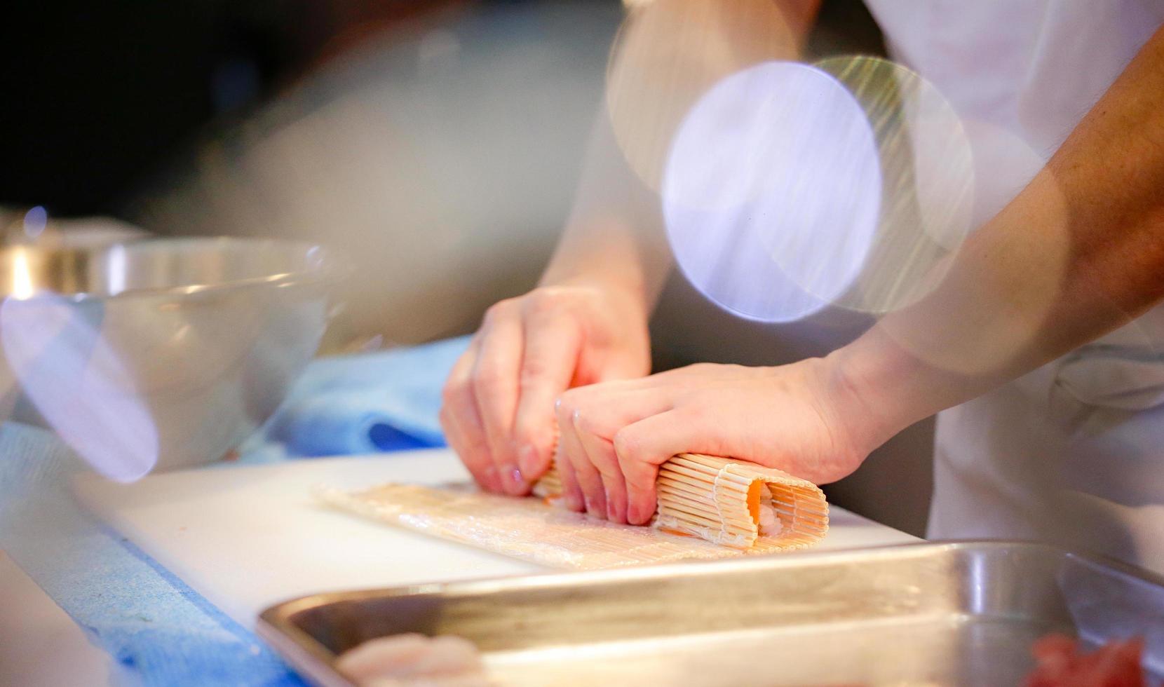 chef-kok handen die Japans eten bereiden, chef-kok die sushi maakt foto