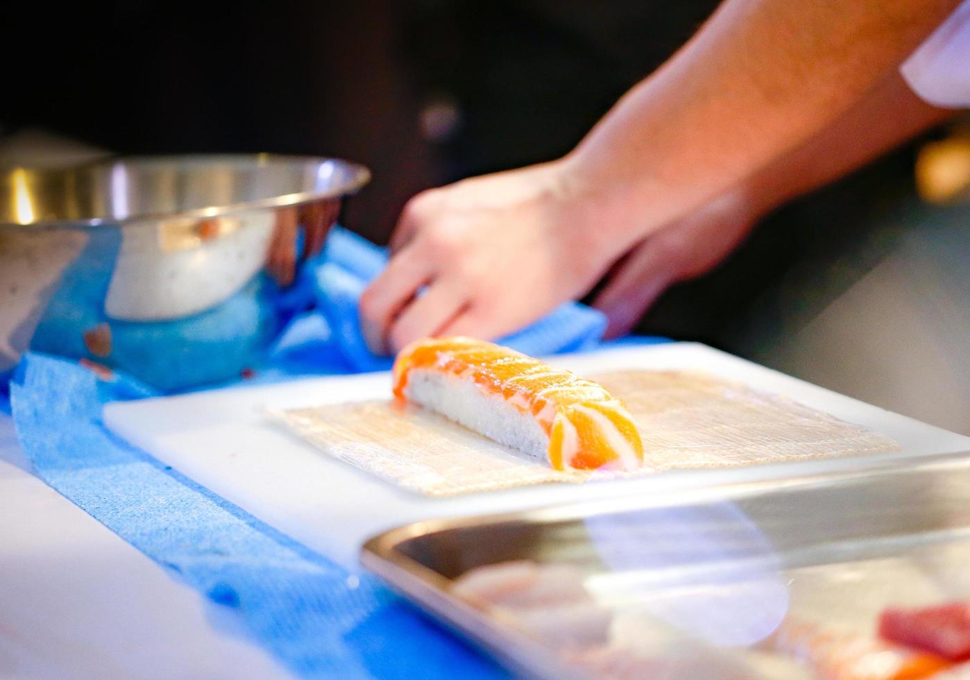 chef-kok handen die Japans eten bereiden, chef-kok die sushi maakt foto