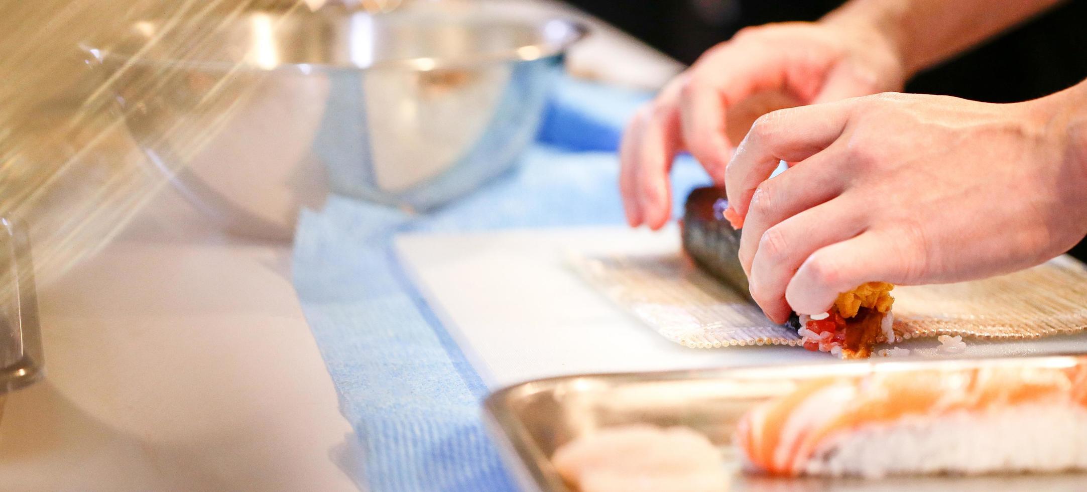 chef-kok handen die Japans eten bereiden, chef-kok die sushi maakt foto