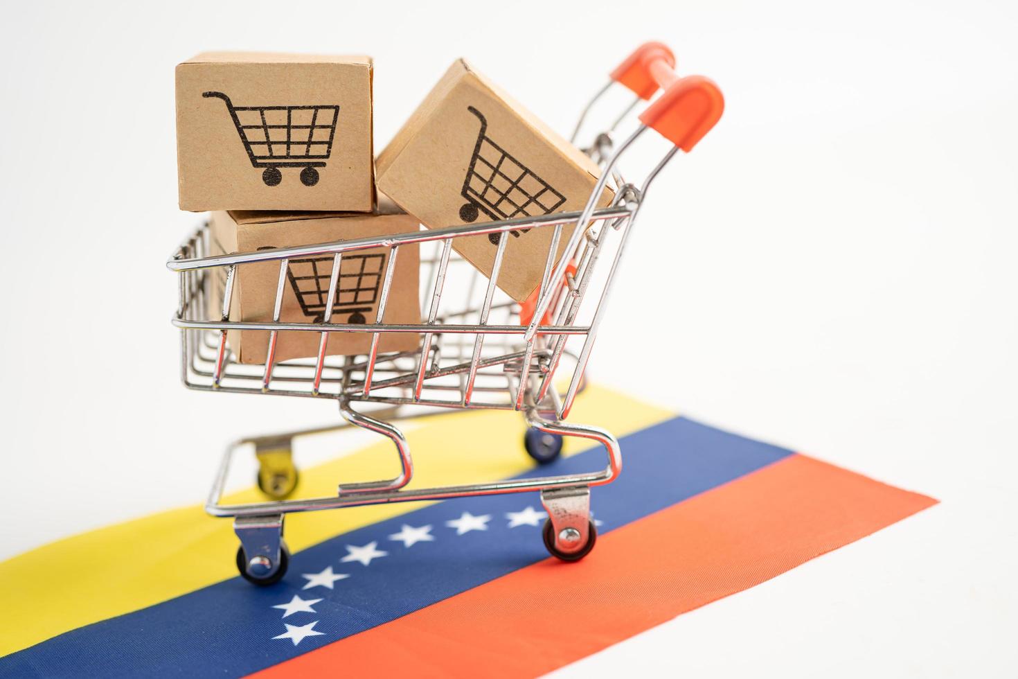 doos met winkelwagenlogo en vlag van venezuela foto