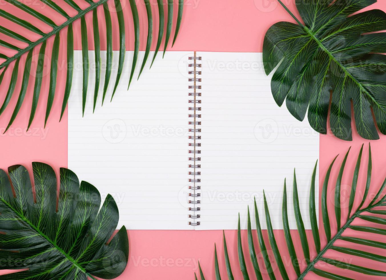 wit dagboekboek met groene planten op roze achtergrond foto