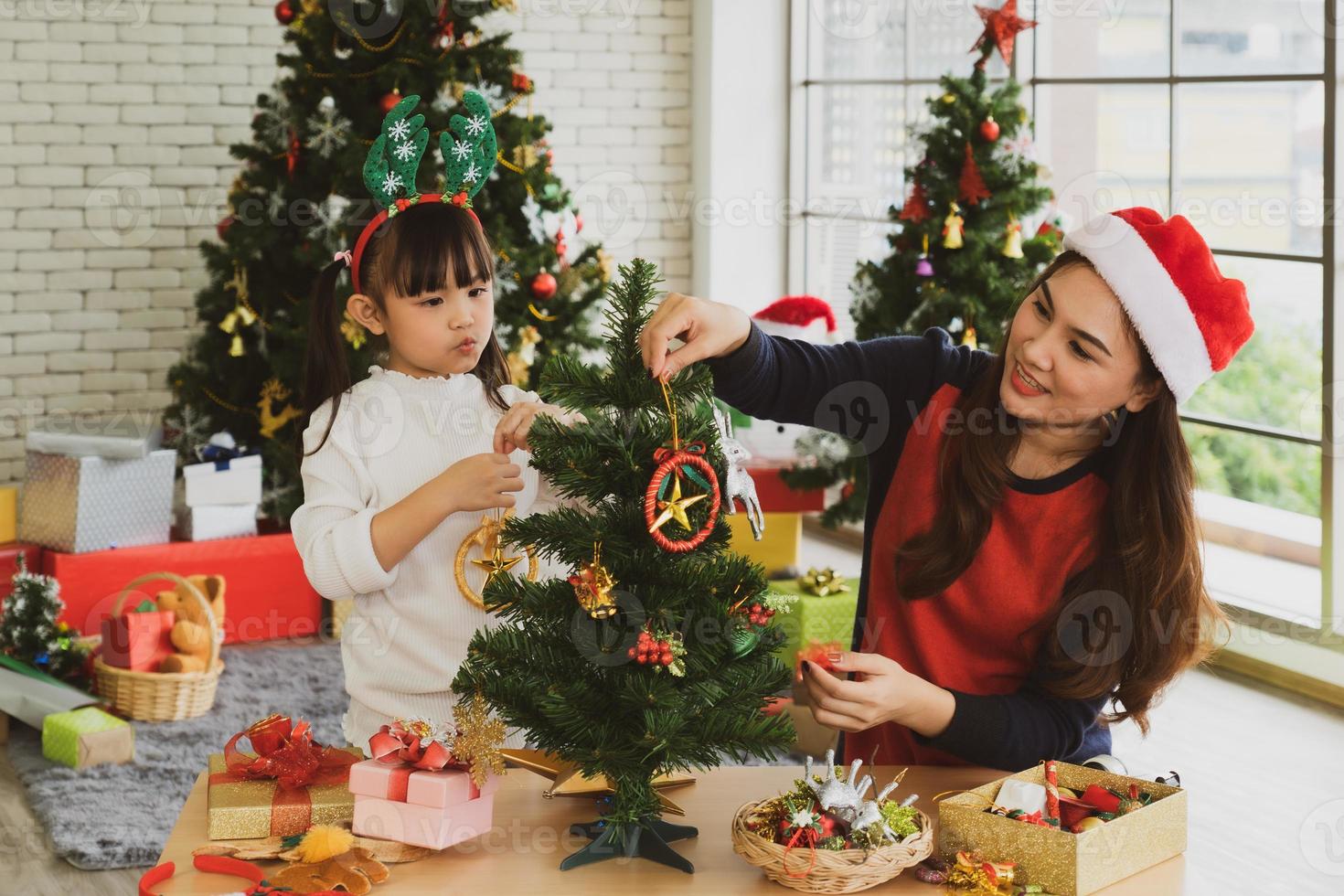 Aziatische moeder en kind versieren samen kerstboom foto