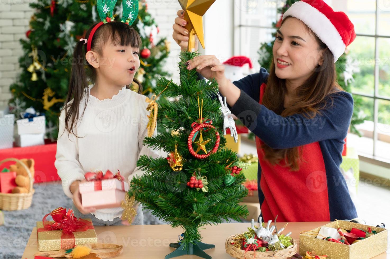 Aziatische moeder en kind versieren samen kerstboom foto