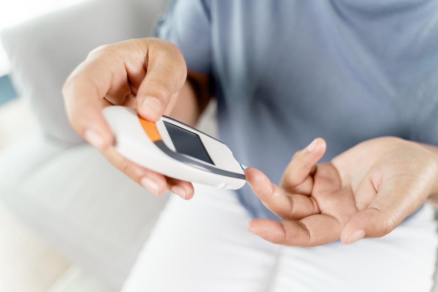 vrouw controleert bloedsuikerspiegel met digitale glucosemeter foto