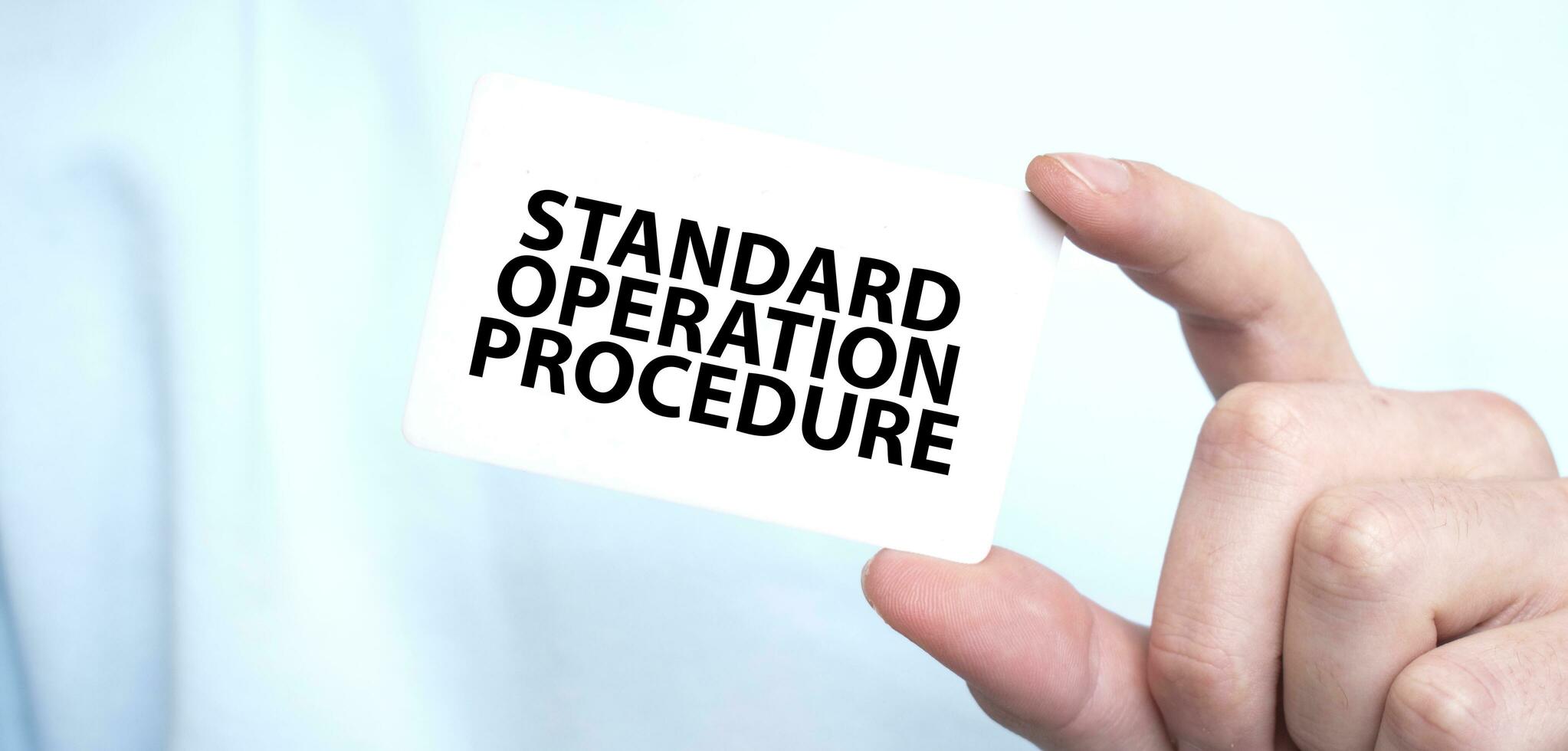 Mens in blauw sweater Holding een kaart met tekst standaard- operatie procedure, bedrijf concept foto