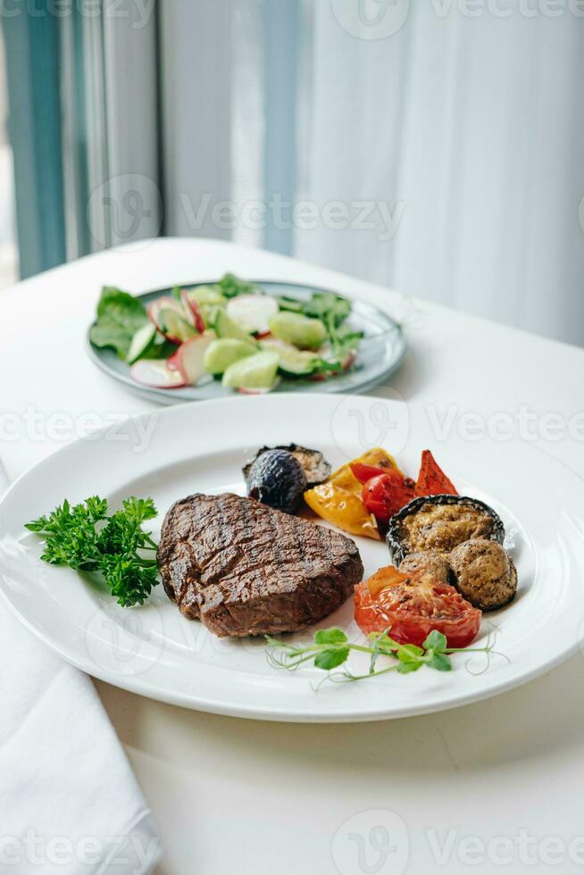 rundvlees steak met gegrild groenten en kruiden Aan een licht achtergrond foto