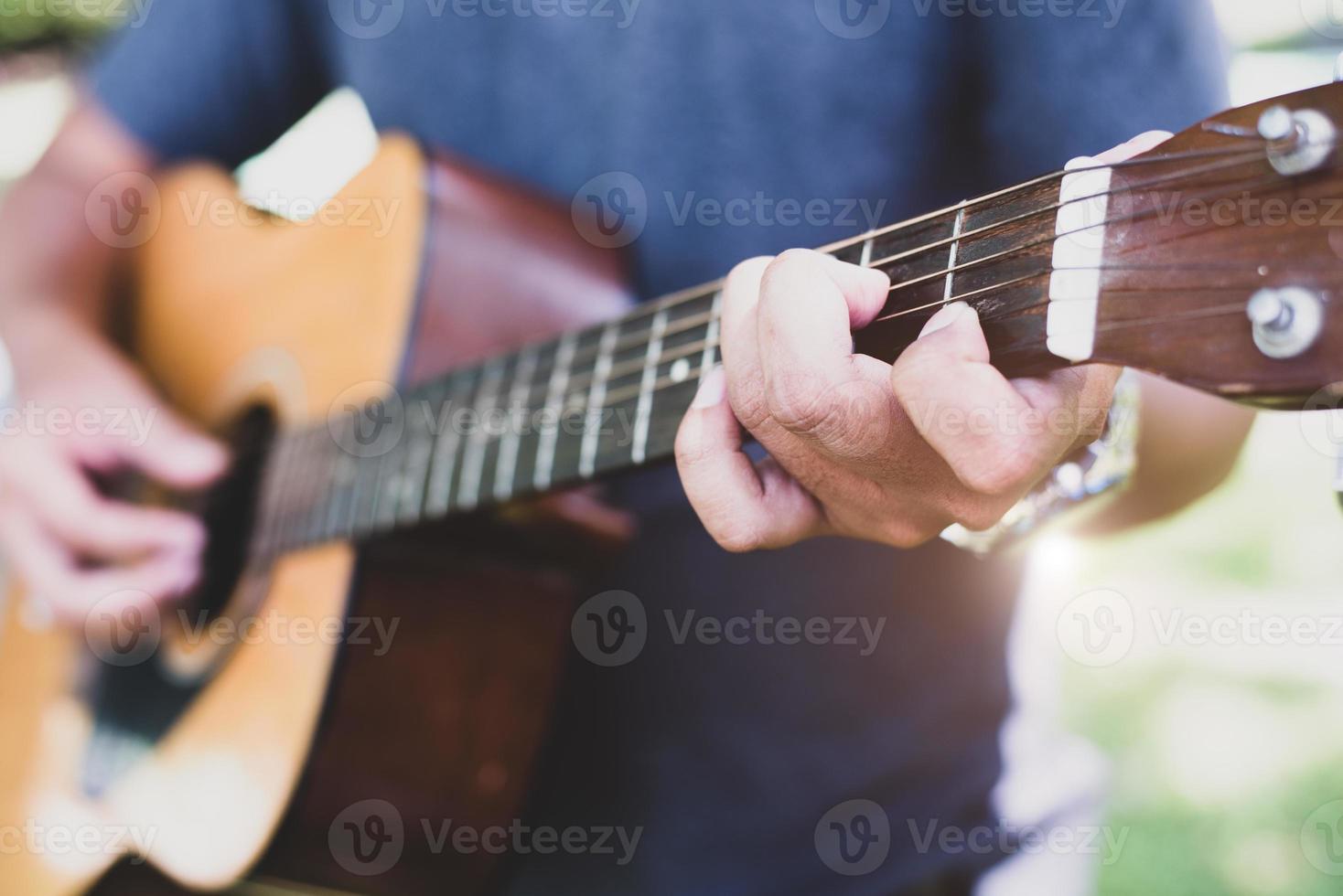 close-up van de hand van de gitarist die gitaar speelt foto