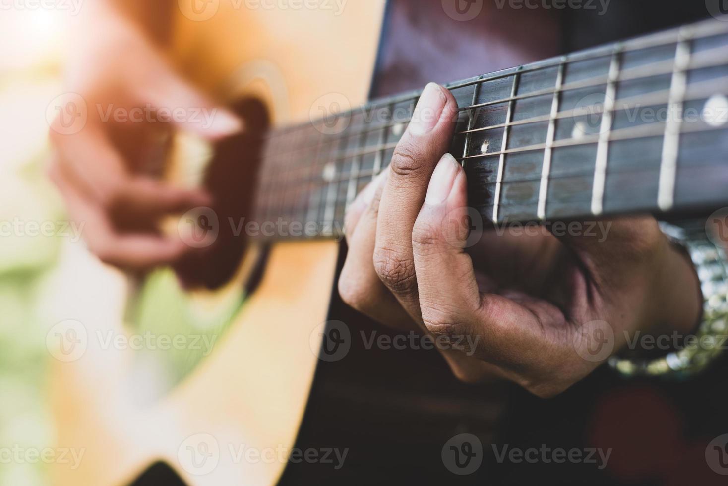 close-up van de hand van de gitarist die gitaar speelt foto