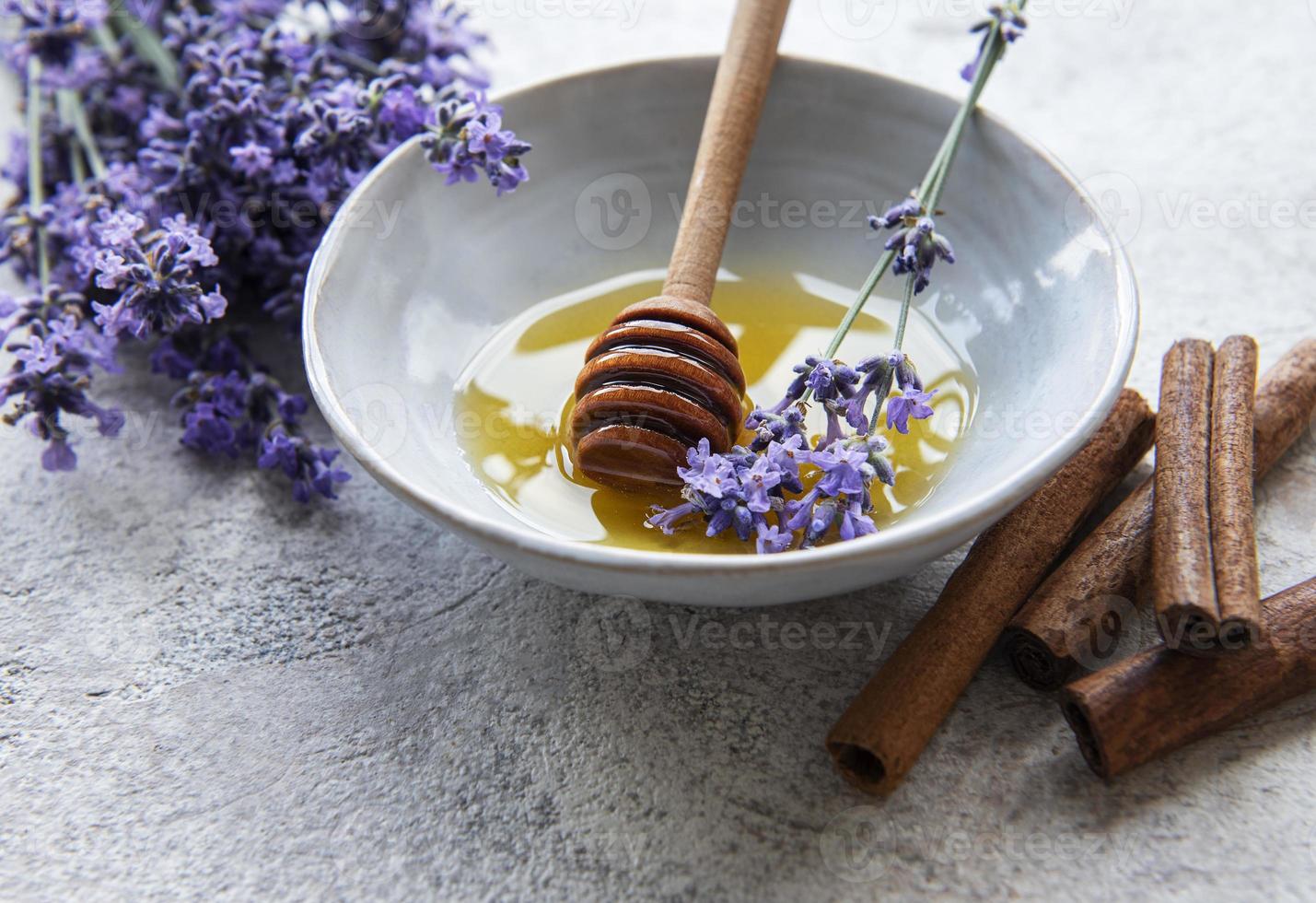 kom met honing en verse lavendelbloemen foto