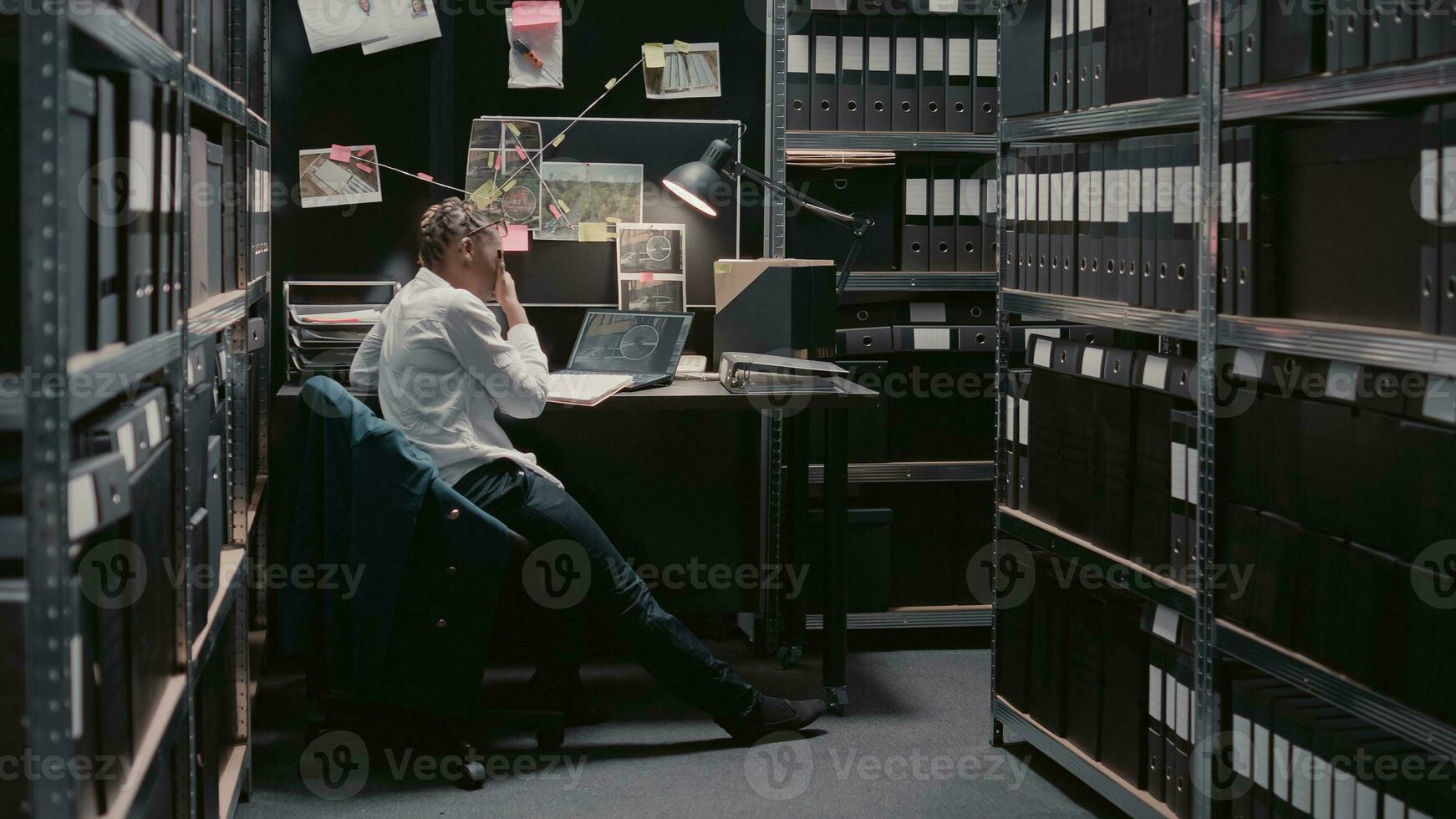 privaat officier lezing geval het dossier informatie in archief, proberen naar gedrag crimineel onderzoek en vangst verdachte. jong politievrouw herzien toezicht beeldmateriaal in incident kamer. foto