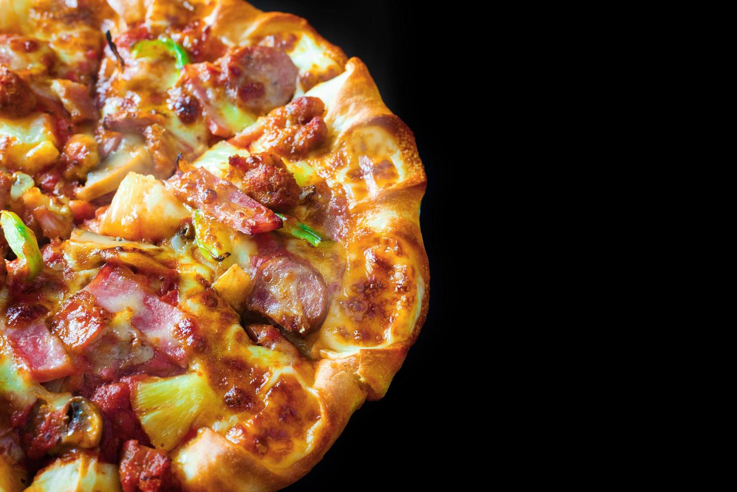 bovenaanzicht van pizza kaas ham spek pepperoni geïsoleerde zwarte achtergrond foto