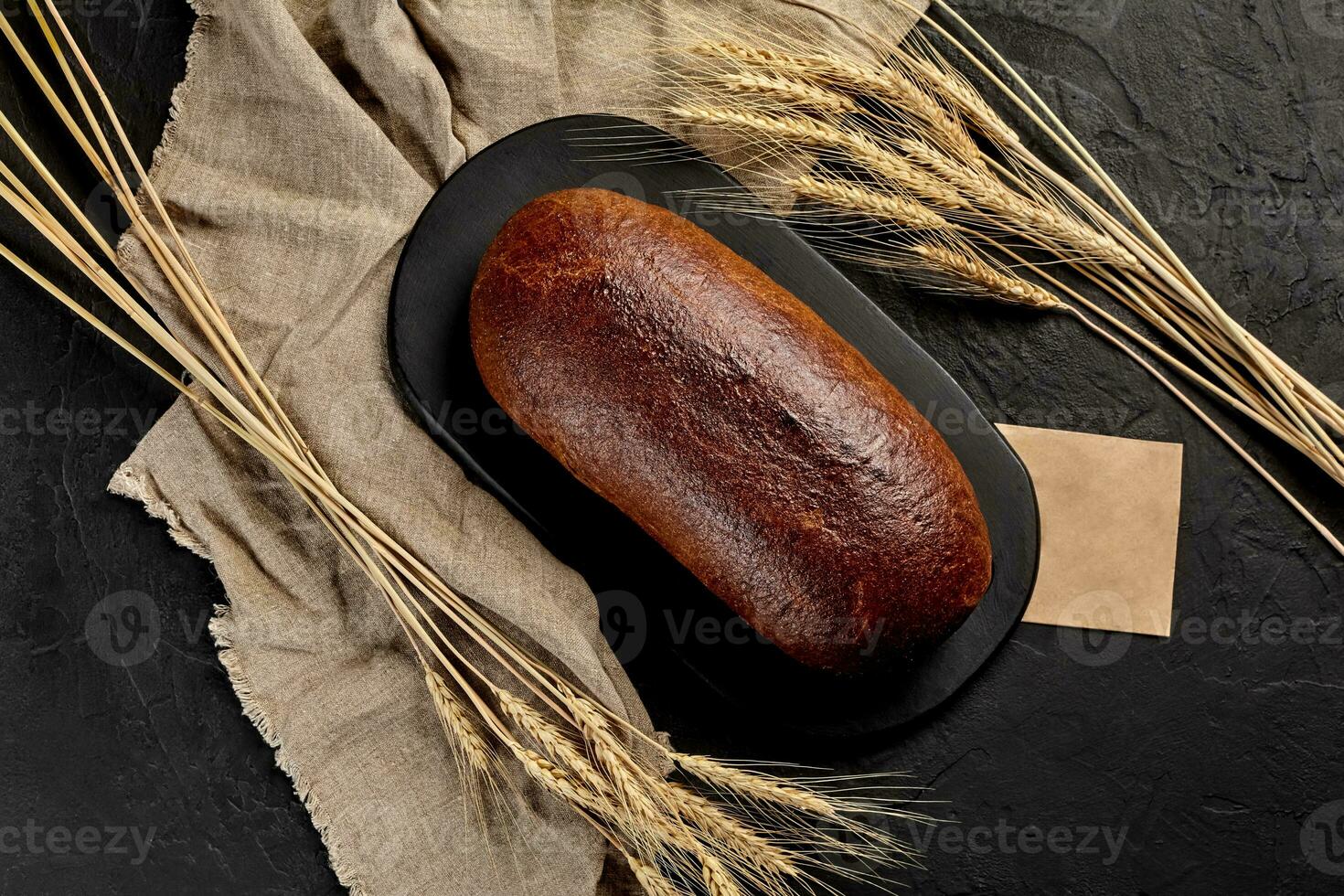 geheel rogge brood met oren van tarwe, jute en stuk van ambacht papier foto