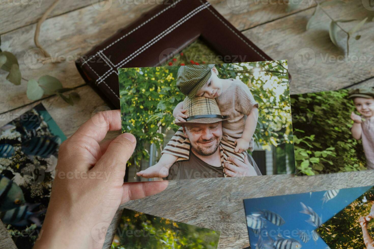 famale hand- houdt gedrukt foto van familie foto archief.