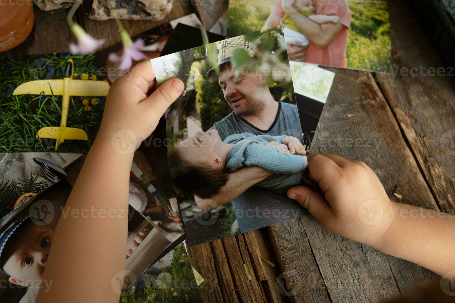 foto het drukken concept. kleuter jongen handen Holding gedrukt foto's.