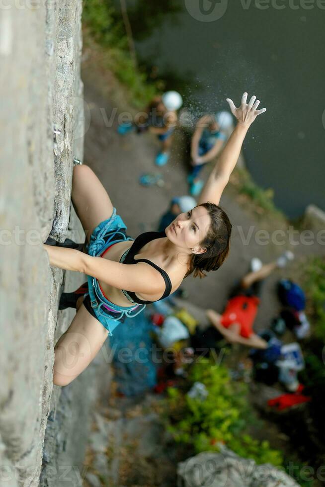 een meisje klimt een steen. vrouw verloofd in extreem sport. foto