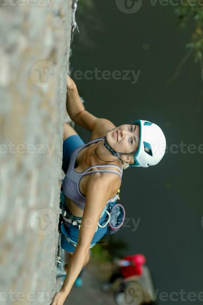 een meisje klimt een steen. vrouw verloofd in extreem sport. foto