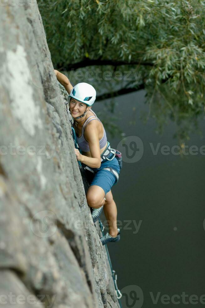 een meisje klimt een steen. vrouw verloofd in extreem sport. foto