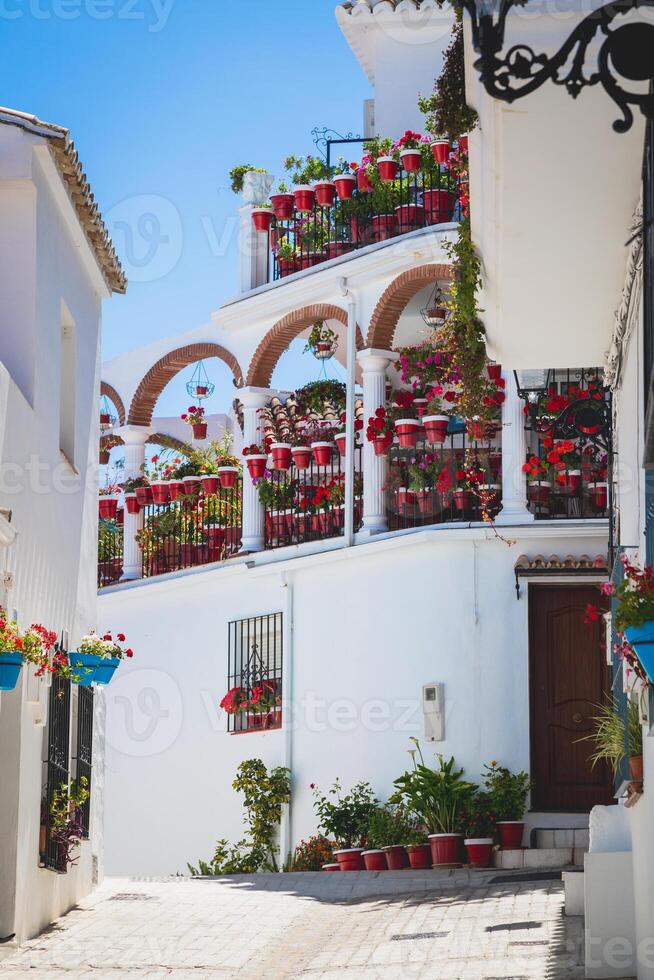 pittoresk straatje van mijas met bloempotten in gevels. andalusisch wit dorp. costa del sol. Zuid-Spanje foto