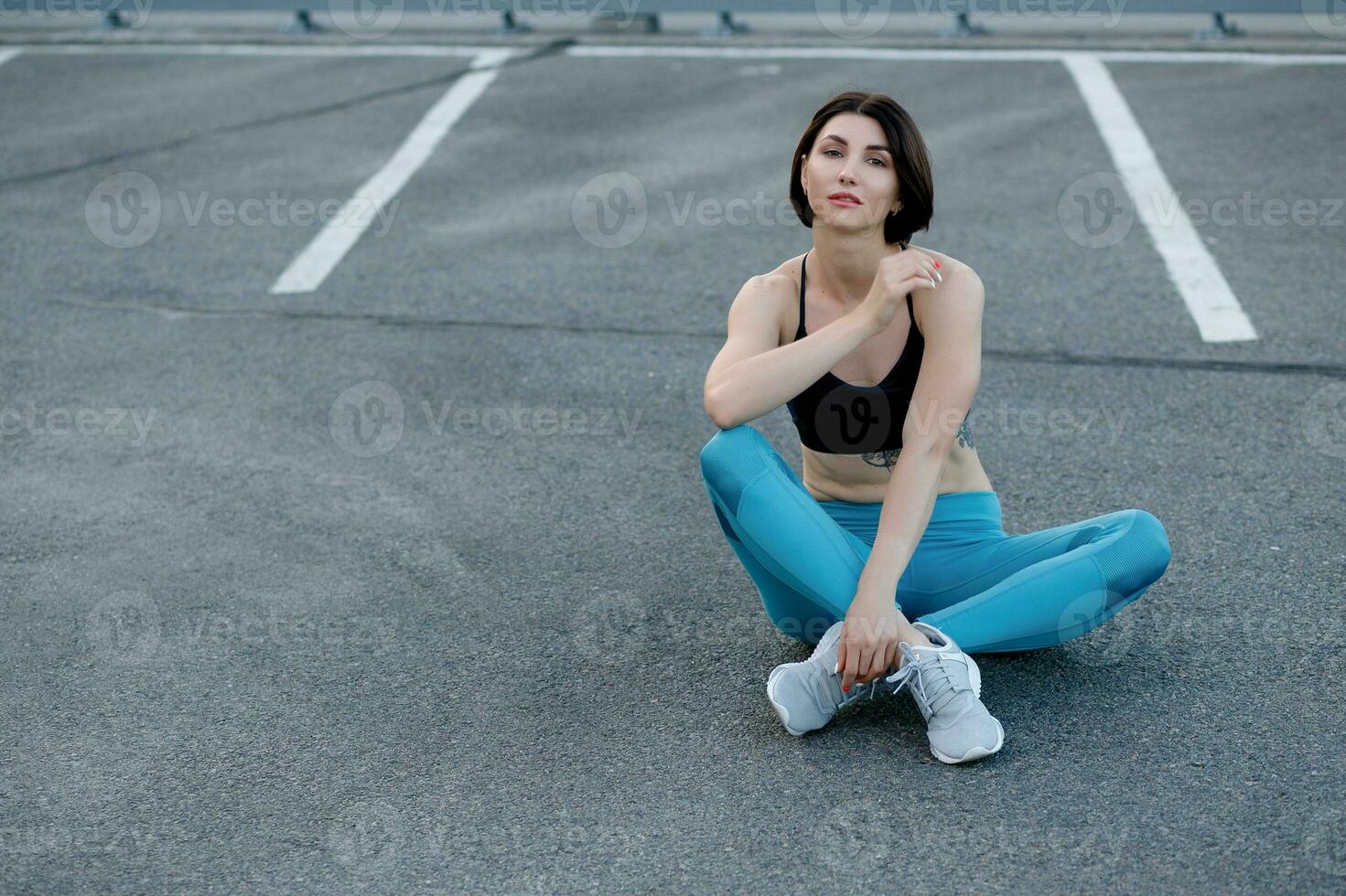 fit jong vrouw zittend buitenshuis na training sessie in ochtend. foto