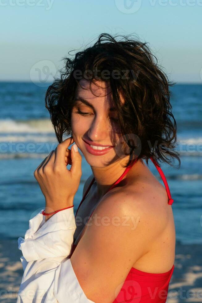 sexy terug van een mooi vrouw in rood bikini Aan zee achtergrond foto