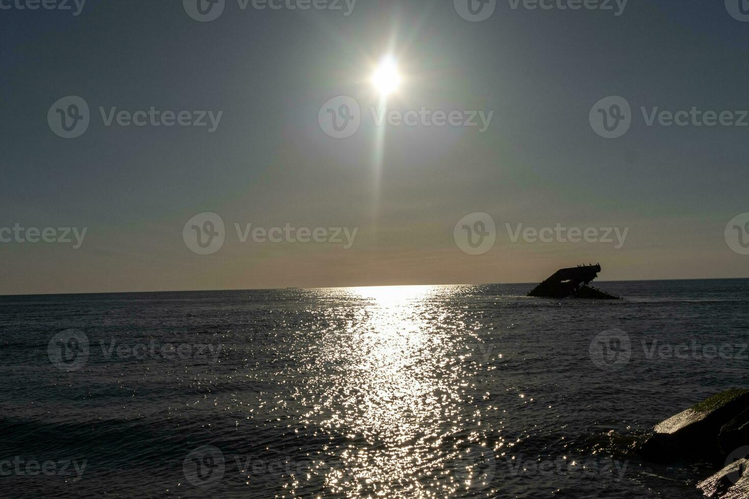 zonsondergang strand in kaap mei nieuw Jersey waar u kan krijgen een Super goed visie van de zon gaan naar beneden aan de overkant de oceaan en de baai. de reflectie van de zon Aan de water met de gezonken schip looks zo mooi. foto