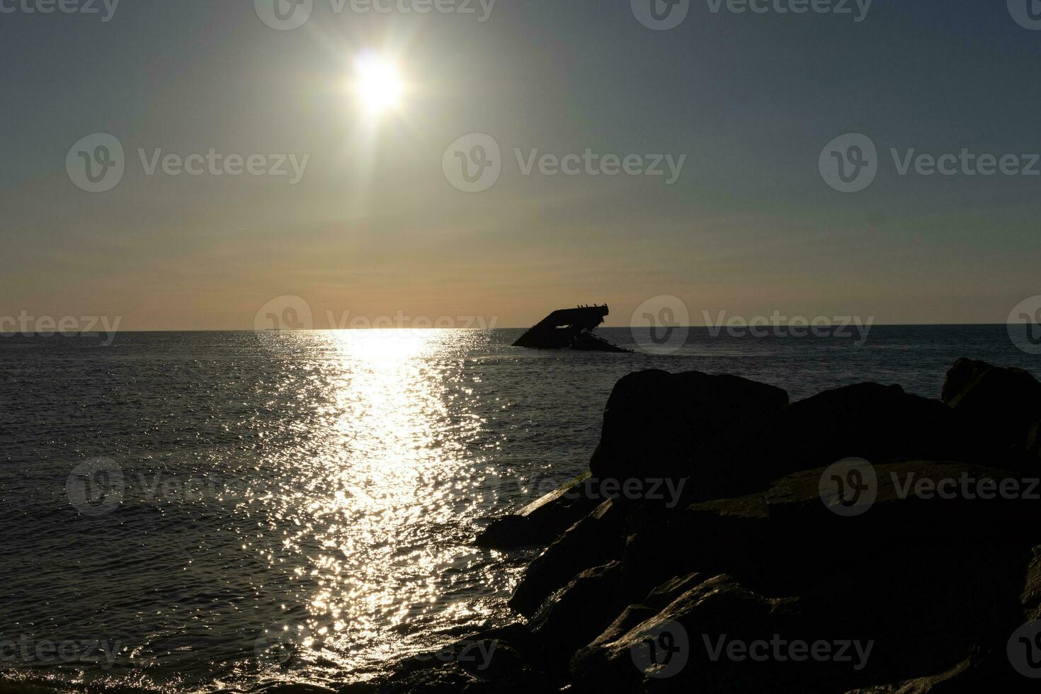 zonsondergang strand in kaap mei nieuw Jersey waar u kan krijgen een Super goed visie van de zon gaan naar beneden aan de overkant de oceaan en de baai. de reflectie van de zon Aan de water met de gezonken schip looks zo mooi. foto