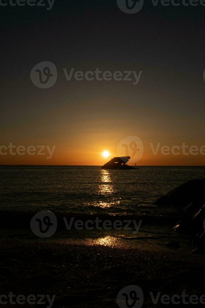 zonsondergang strand in kaap mei nieuw Jersey waar u kan krijgen een Super goed visie van de zon gaan naar beneden aan de overkant de oceaan en de baai. de reflectie van de zon Aan de water met de gezonken schip looks zo mooi. foto