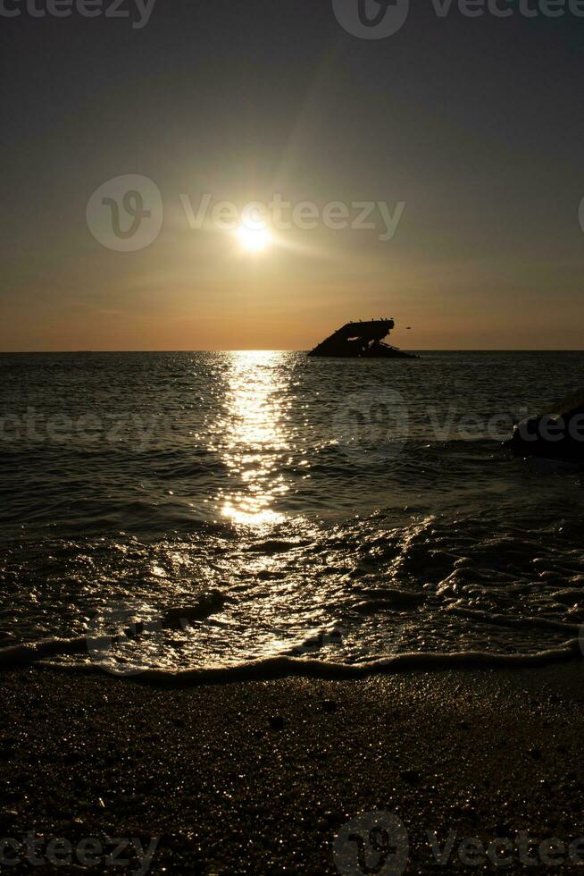 zonsondergang strand in kaap mei nieuw Jersey waar u kan krijgen een Super goed visie van de zon gaan naar beneden aan de overkant de oceaan en de baai. de reflectie van de zon Aan de water met de gezonken schip looks zo mooi. foto