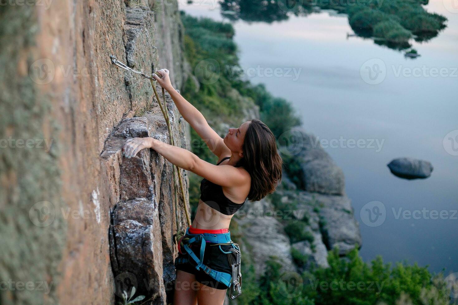 een meisje klimt een steen. vrouw verloofd in extreem sport. foto