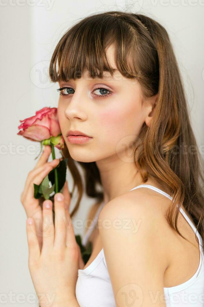 weinig mooi meisje in roze houdt de boeket van rozen. foto