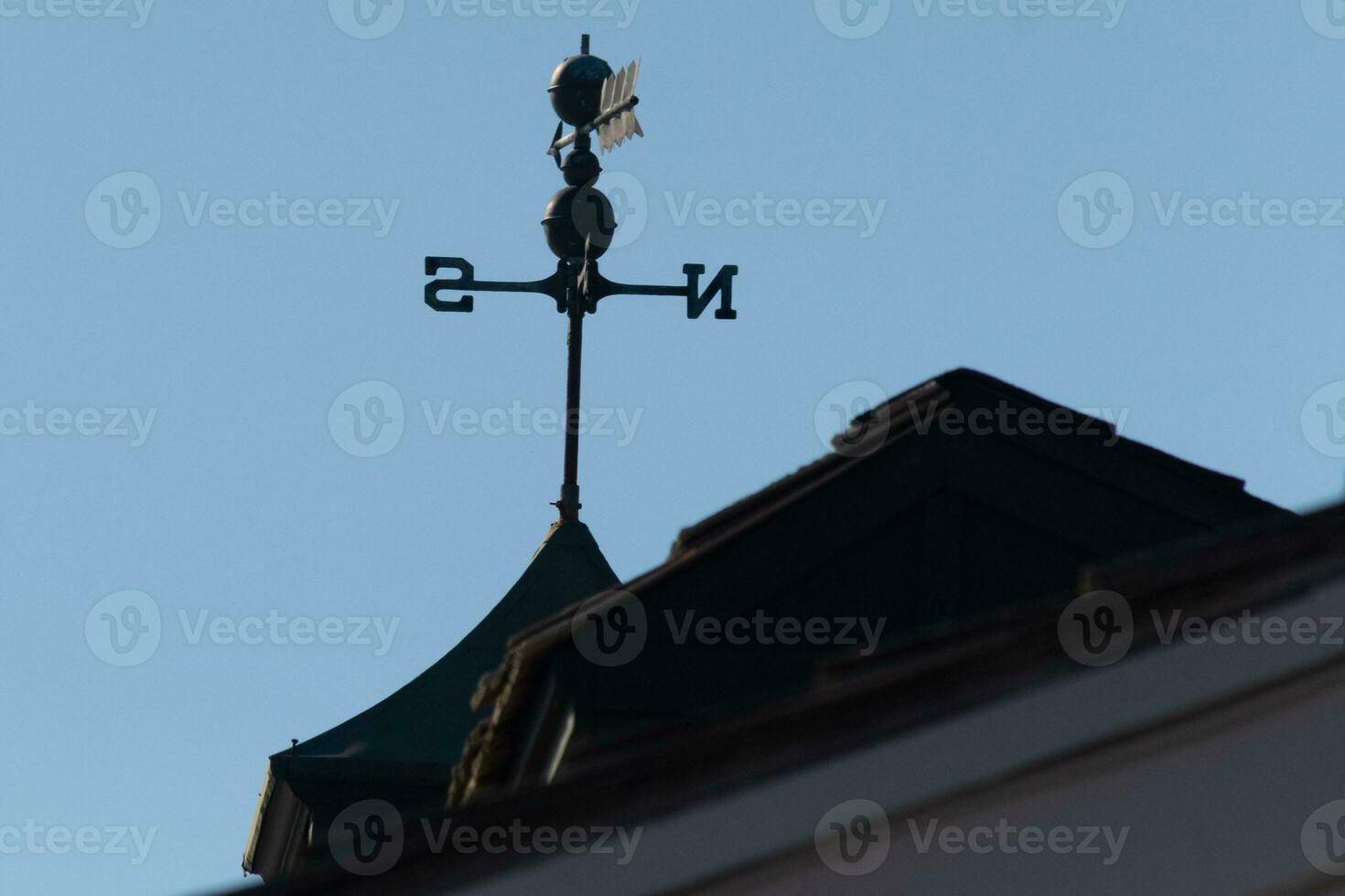 deze weer vin was mooi Aan de dak in tegenstelling tegen de lucht. de schimmig beeld met de Doorzichtig blauw lucht in de achtergrond. de noorden, zuiden, oosten, en west tonen richting van de wind. foto