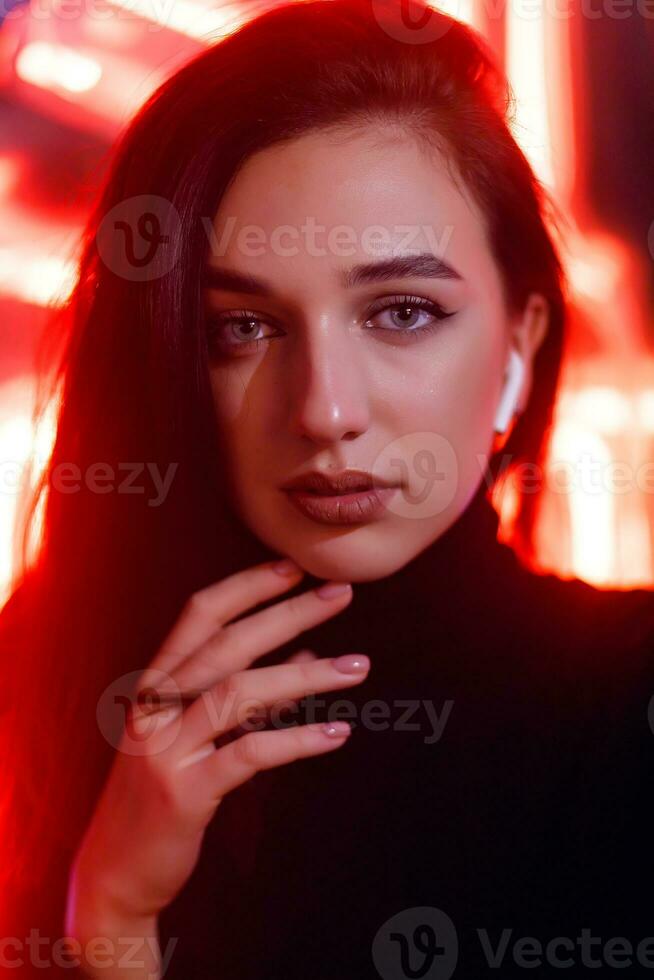 portret van een meisje Aan de achtergrond van een neon teken van een winkel venster foto