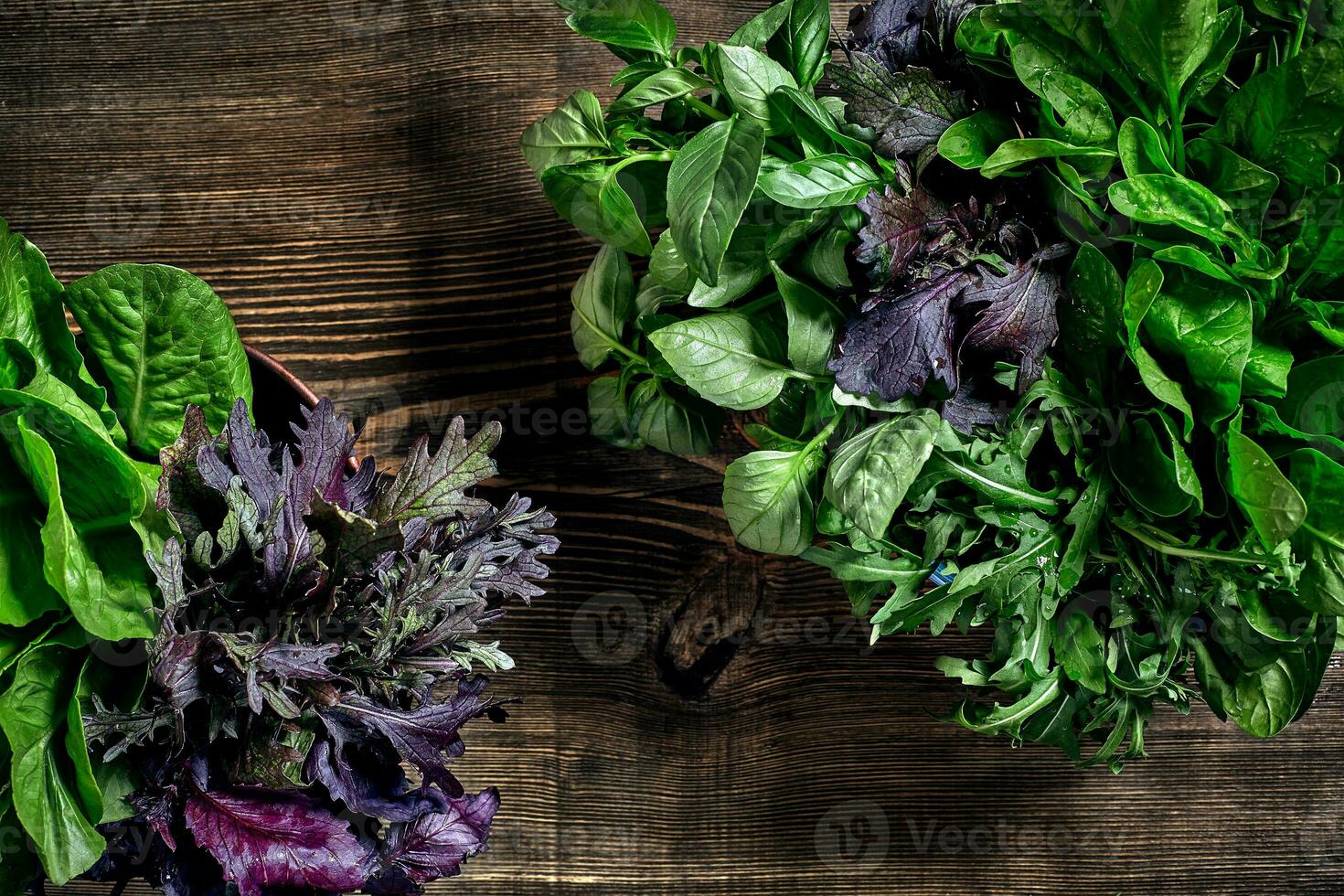 verscheidenheid van vers biologisch kruiden Aan houten achtergrond. vers geoogst kruiden inclusief basilicum, rucola. top visie. kopiëren ruimte. foto