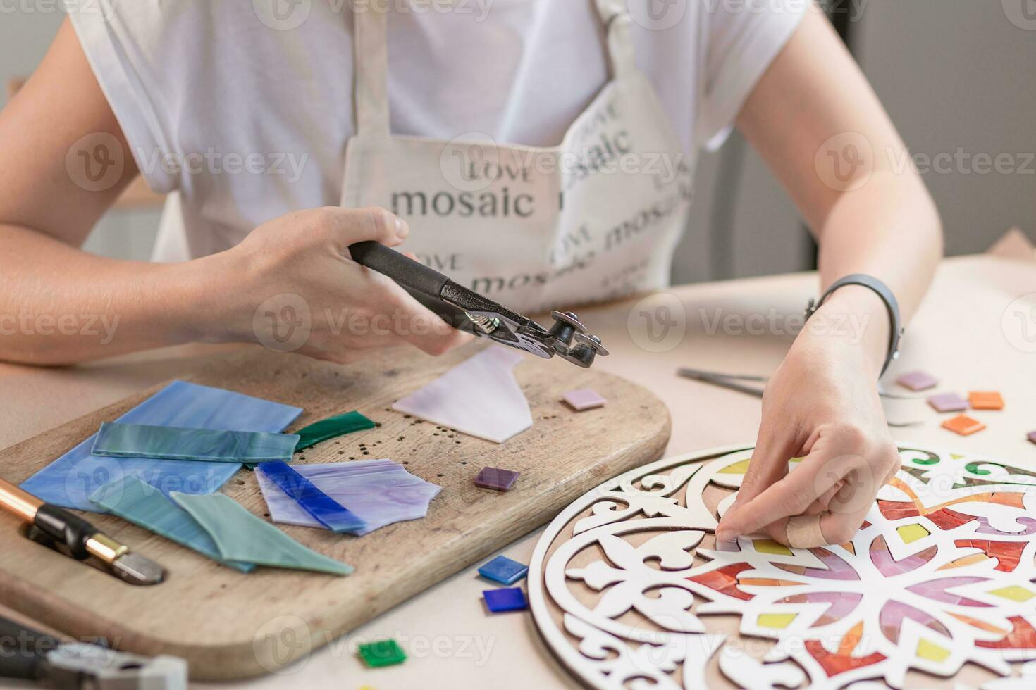 handen van meester werken Aan nieuw modern kleurrijk mozaïek. detailopname foto