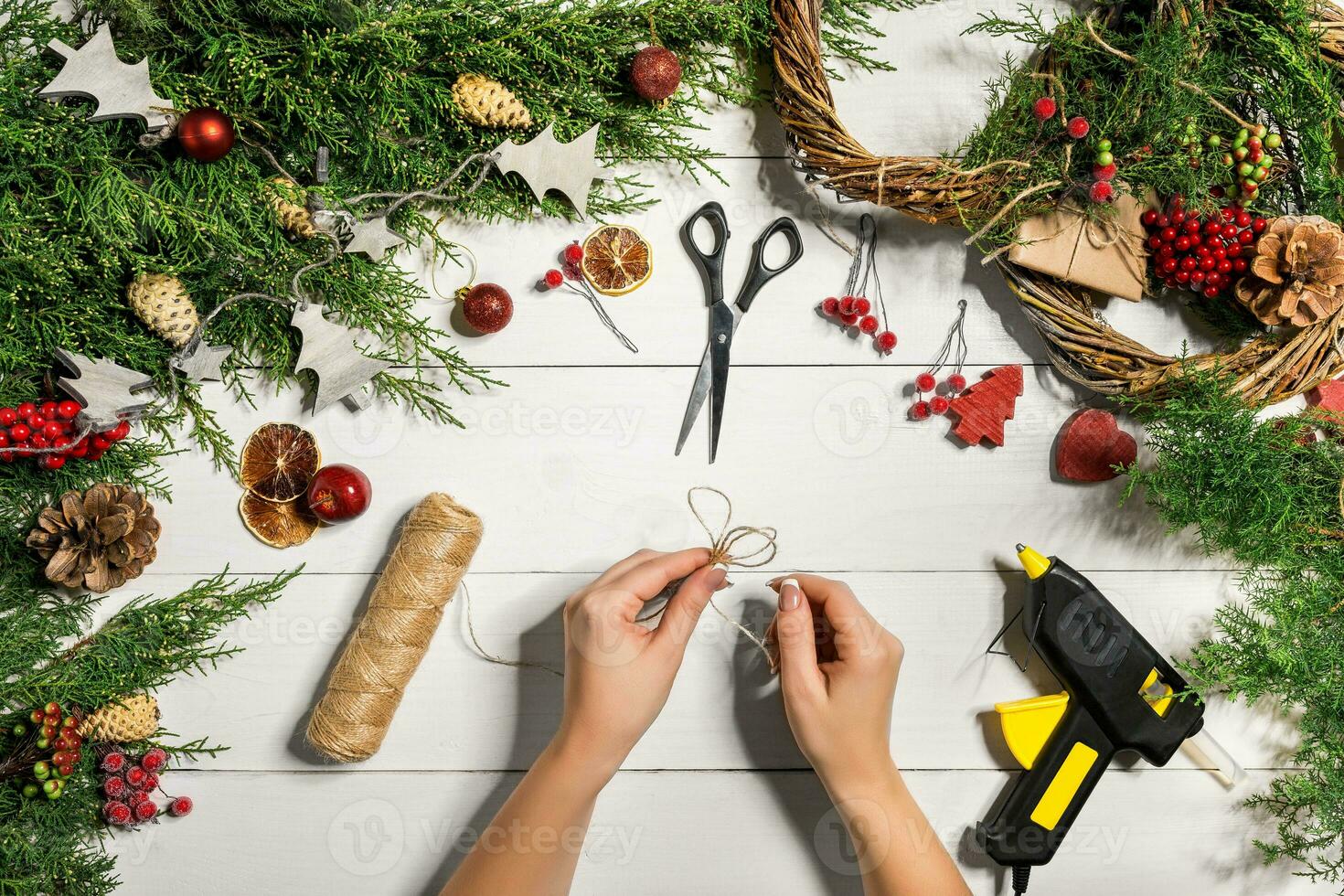 Kerstmis handgemaakt diy achtergrond. maken ambacht Kerstmis krans en ornamenten. top visie van wit houten tafel met vrouw handen. foto