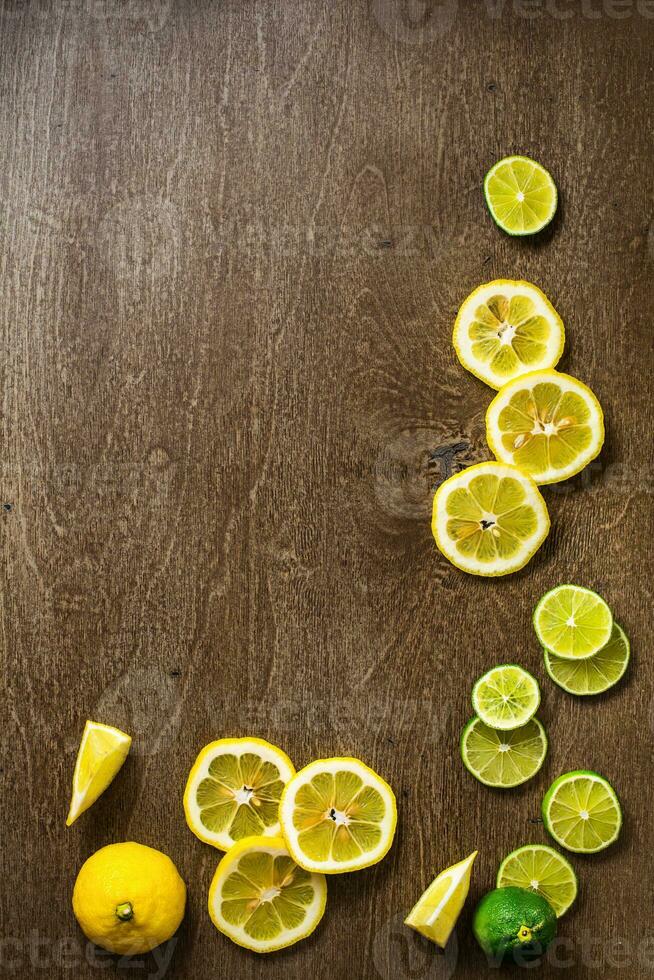 gesneden citroen, limoen Aan leisteen en houten teller top achtergrond foto