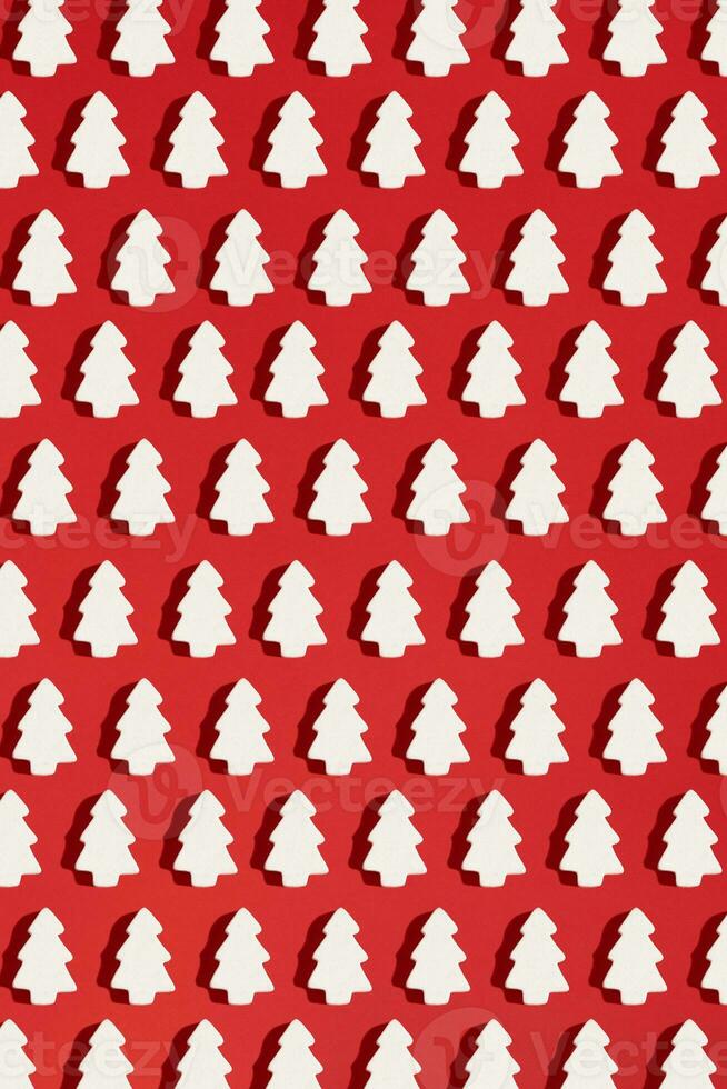 patroon gemaakt van wit Kerstmis decoratie met Kerstmis boom Aan rood achtergrond. Kerstmis behang. foto