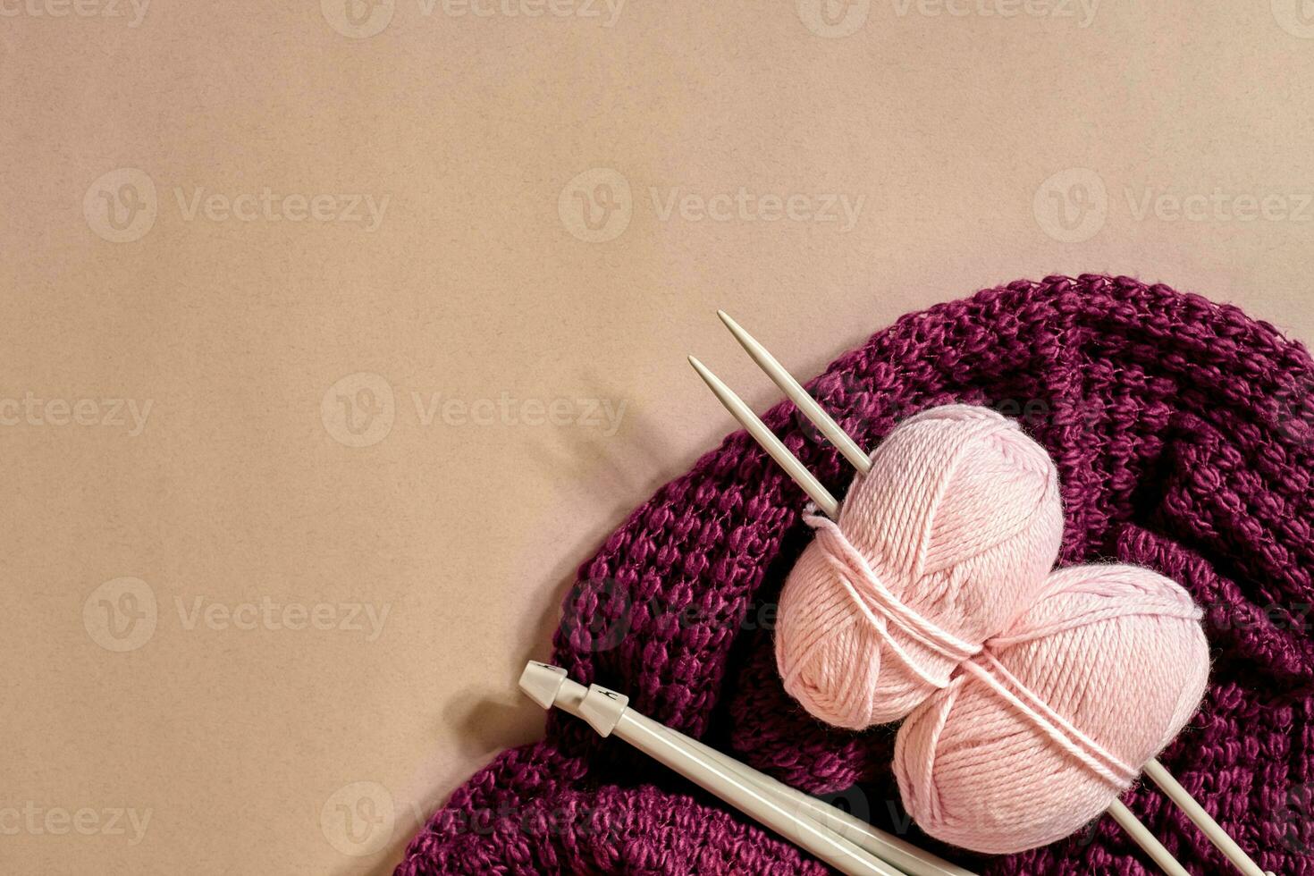 twee roze breiwerk garen ballen, breiwerk naalden en en Purper gebreid plaid top visie foto