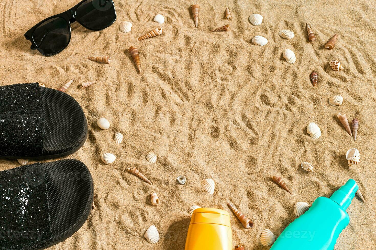 zwart slippers en zonnebril, zeeschelp Aan zand. met plaats voor uw tekst. top visie foto