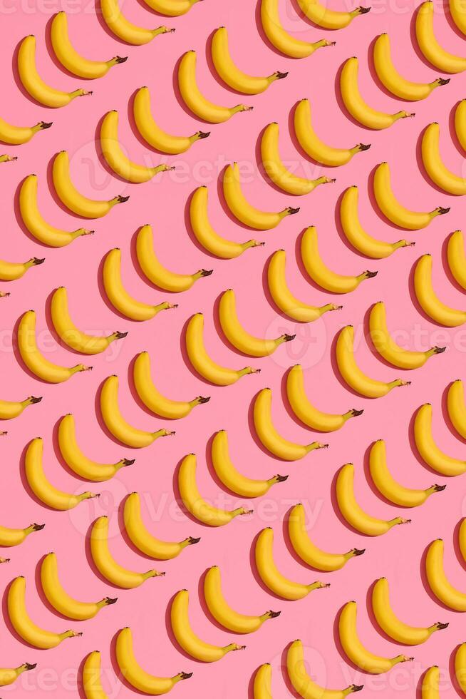 patroon samenstelling van geel zoet bananen aan het liegen De volgende naar een roze achtergrond , top visie foto