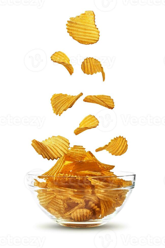 gegroefd aardappel chips vallend naar beneden in glas schaal, geïsoleerd Aan wit achtergrond met kopiëren ruimte voor tekst, afbeeldingen. krokant chips. reclame. detailopname. foto