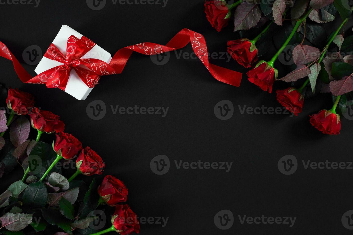 rood rozen, ring en geschenk doos Aan zwart achtergrond foto