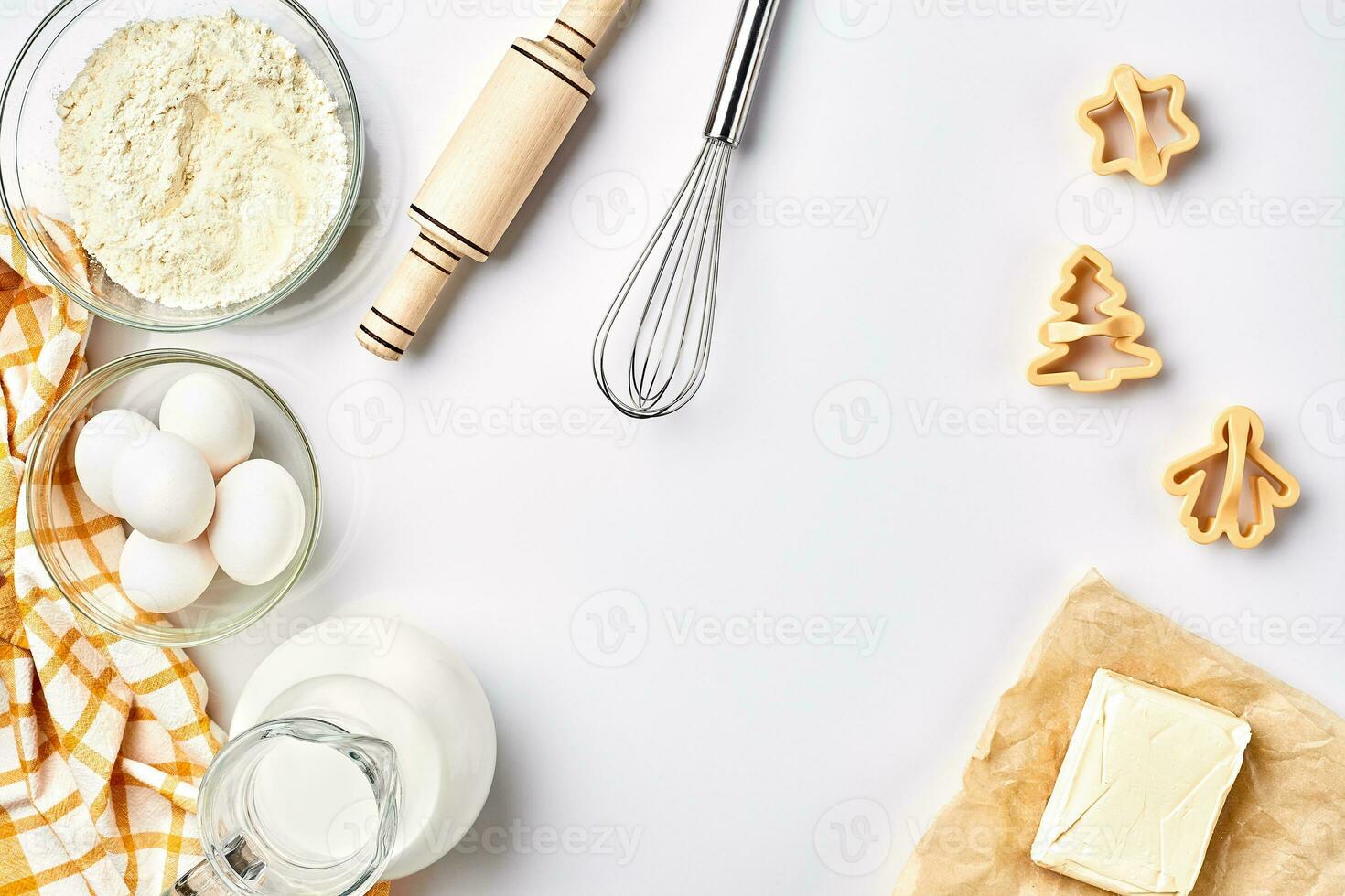 voorwerpen en ingrediënten voor bakken, plastic mallen voor koekjes Aan een wit achtergrond. meel, eieren, rollend pin, garde, melk, boter, room. top visie, ruimte voor tekst foto