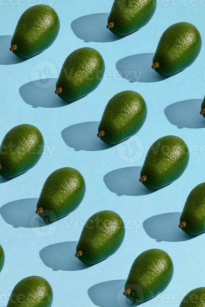 kleurrijk fruit patroon van vers geheel avocado geregeld Aan blauw pastel achtergrond foto