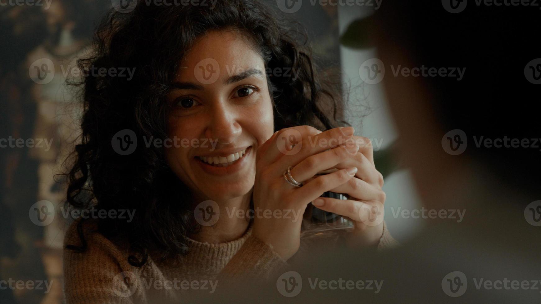 vrouw zit en drinkt koffie terwijl ze met de man aan tafel praat foto