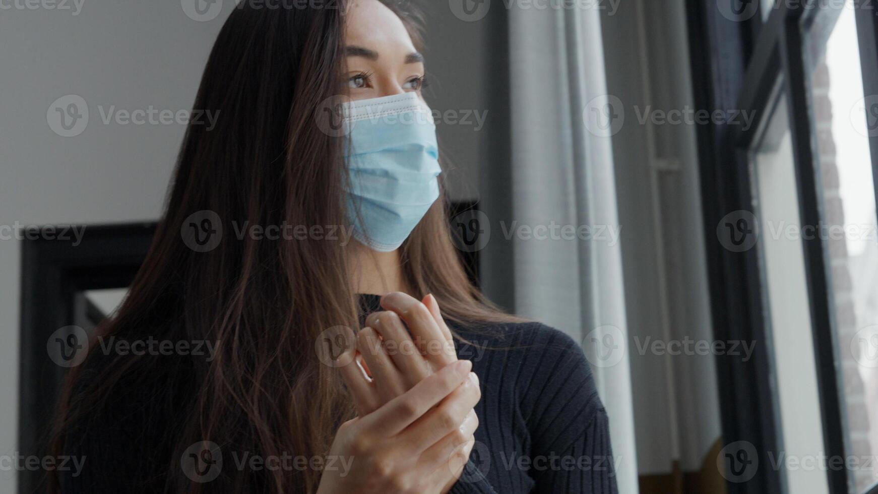 handen van jonge gemengd ras vrouw met gezichtsmasker foto